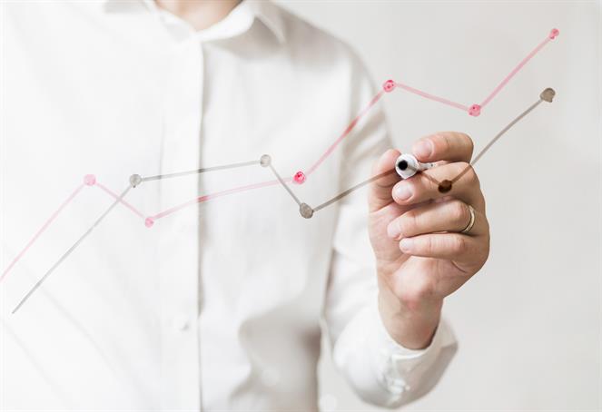 Serious middle aged businessman presenting company business goals to colleagues during meeting in boardroom, male coach training workers, explaining successful strategies on flipchart during briefing