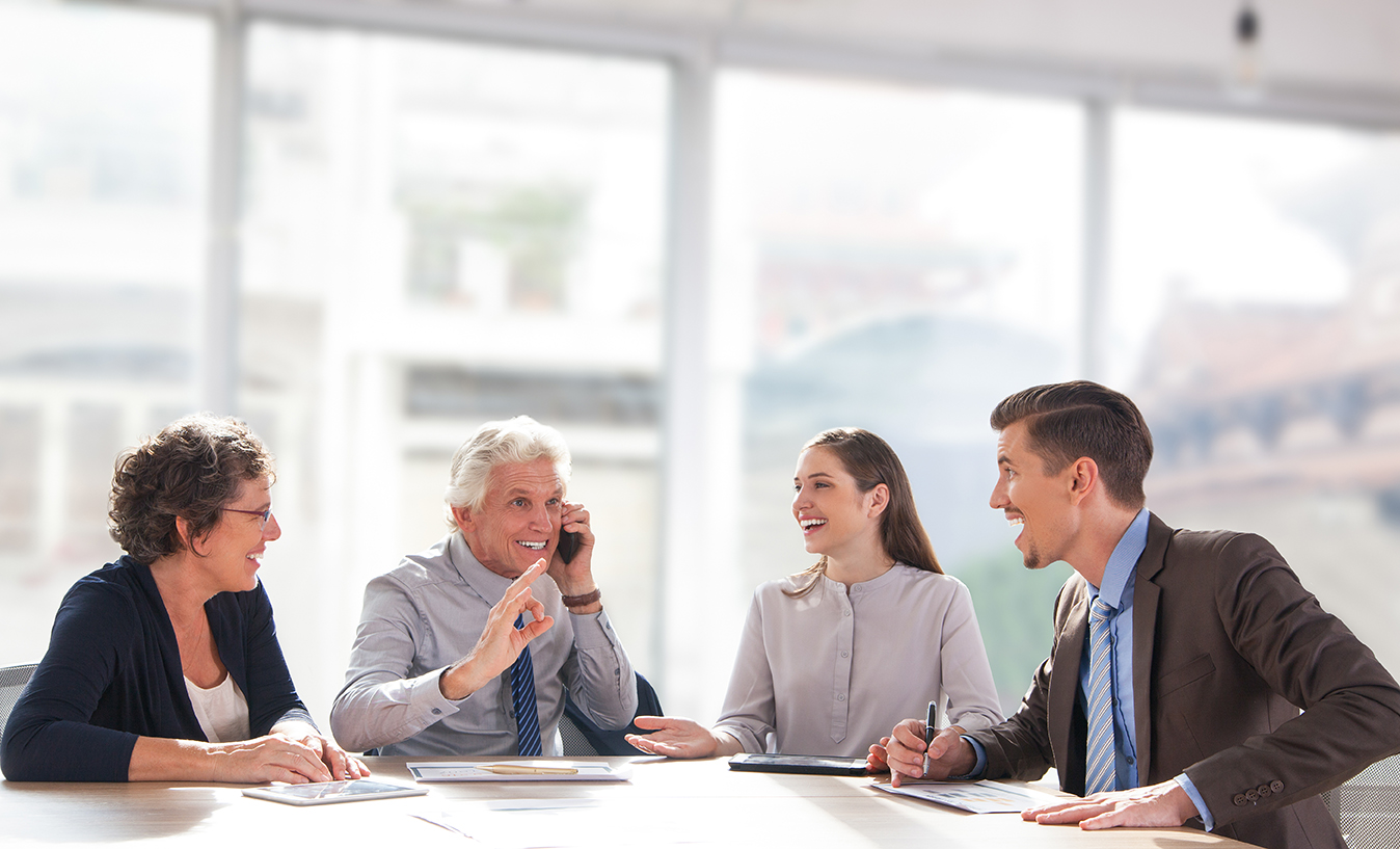 Serious middle aged businessman presenting company business goals to colleagues during meeting in boardroom, male coach training workers, explaining successful strategies on flipchart during briefing