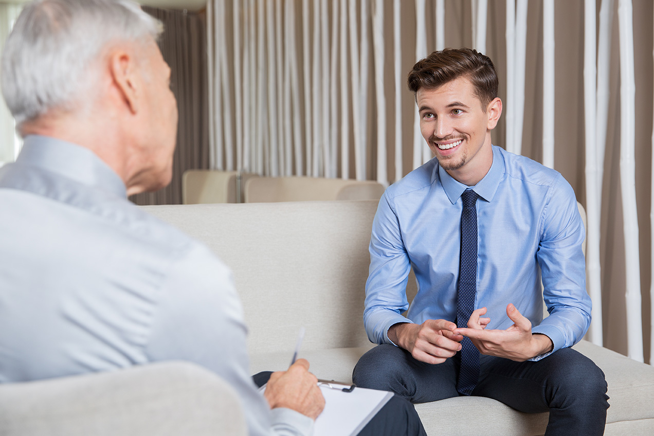 Serious middle aged businessman presenting company business goals to colleagues during meeting in boardroom, male coach training workers, explaining successful strategies on flipchart during briefing